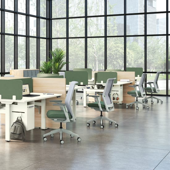 A modern, open-plan office space with large windows overlooking greenery, featuring rows of desks and chairs in a minimalist, neutral color palette.