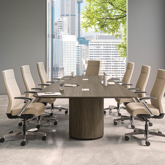 A modern and minimalist conference room with a large wooden table surrounded by white office chairs, overlooking a cityscape through the large windows.