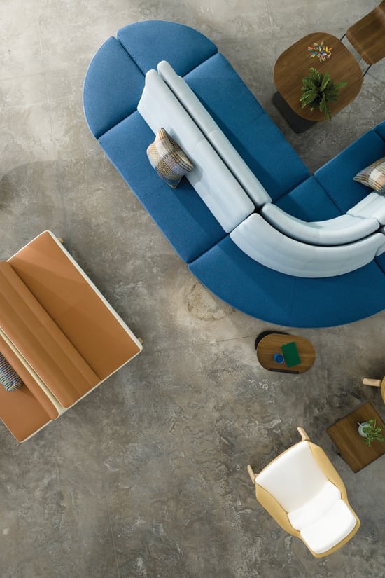 Aerial view of blue and orange modular lounge seating and a variety of bucket chairs and personal tables designed for privacy and collaboration opportunities.