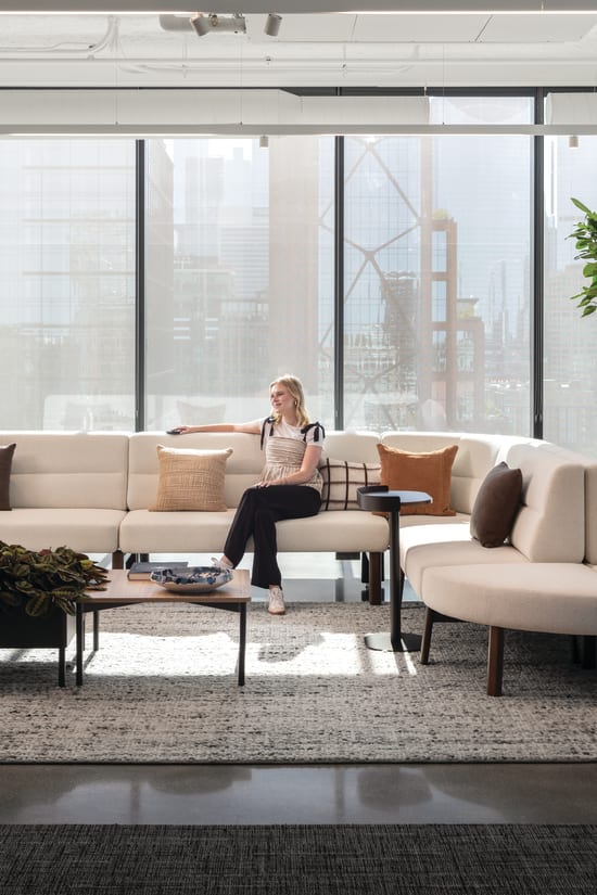 Rectangular coffee table with wood top and slim metal legs, paired with low round side tables for casual lounge use.