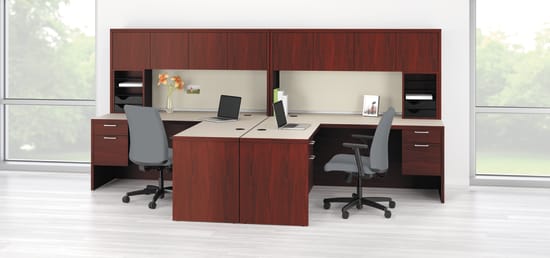 The image depicts a modern office workspace with a wooden desk, computer monitors, and office chairs arranged in a clean and organized manner. The background features large windows, allowing natural light to fill the space.