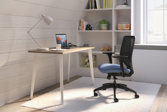 A minimalist home office setup with a wooden desk, a comfortable office chair, and shelves displaying various decorative items and books.