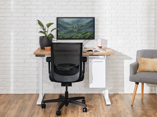 Two white Coordinate Height-Adjustable Bases paired with Coze desk tops and Convergence Task chairs in a small office setting