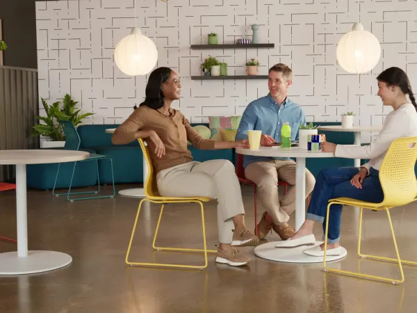 Commons area with red, yellow, and blue Etch chairs at white between tables in front of blue Soco lounge seating.
