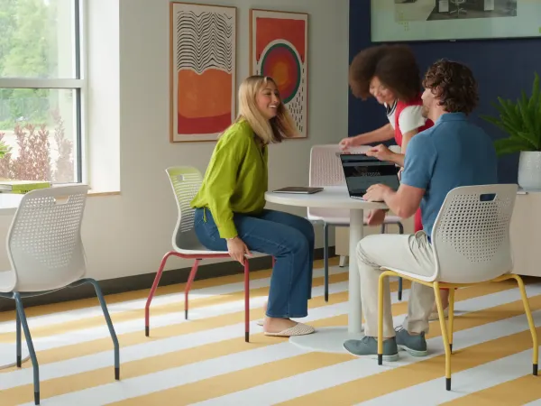 Group of people entering the room and unstacking Etch chairs to sit down at Between tables.