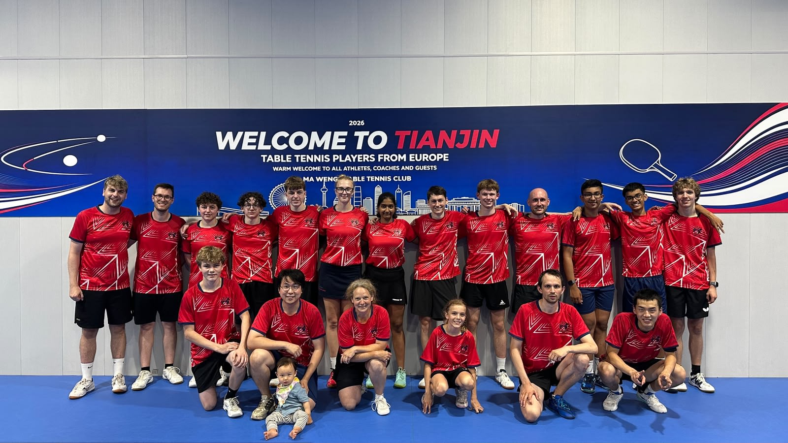 OTTV-Gruppe vor dem Welcome-to-Tianjin-Banner in der Halle