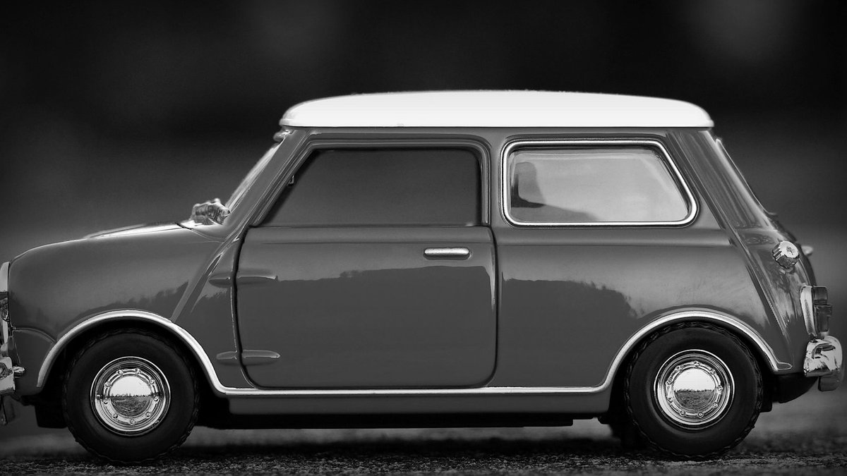 Close-up of a classic Mini toy car in monochrome, highlighting elegant design.
