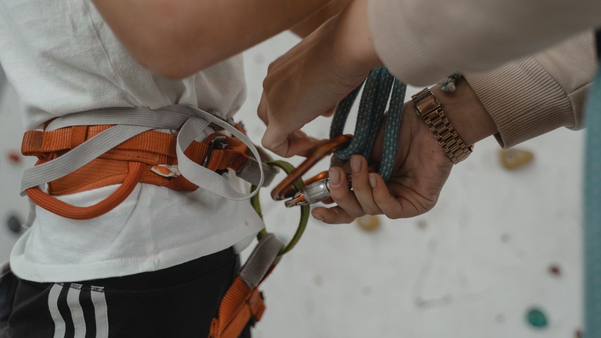 ASD warns agentic AI flaws cannot be fixed inside models Detailed view of a rock climber preparing with harness and ropes. Indoor climbing setup.