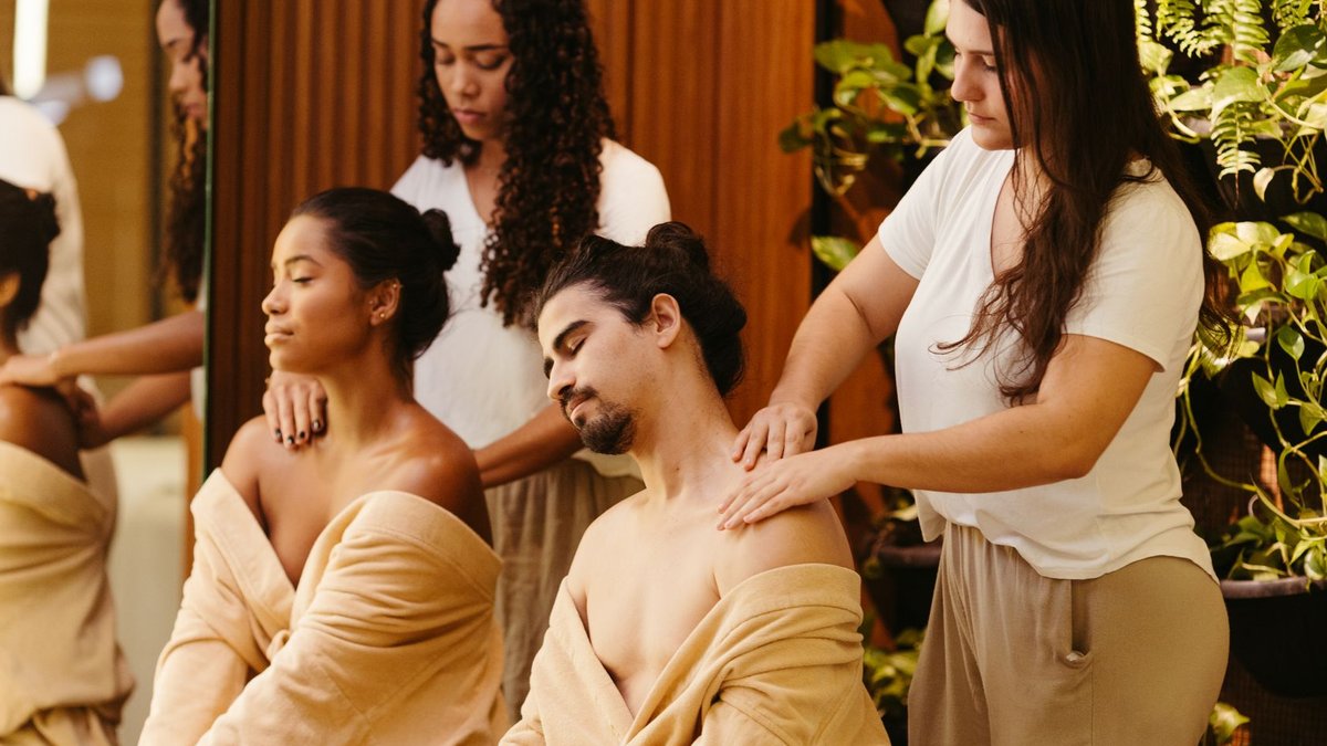 Two clients enjoy a relaxing massage from professional therapists in a spa setting, promoting wellness and relaxation.