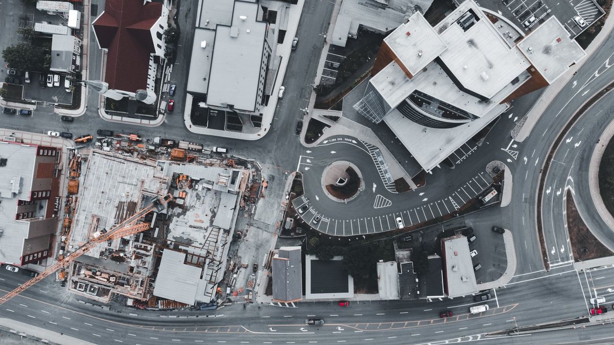 Brownfield Sites Offer Bespoke Home Building Opportunities Top-down view of city streets and a construction site with surrounding buildings and roads.