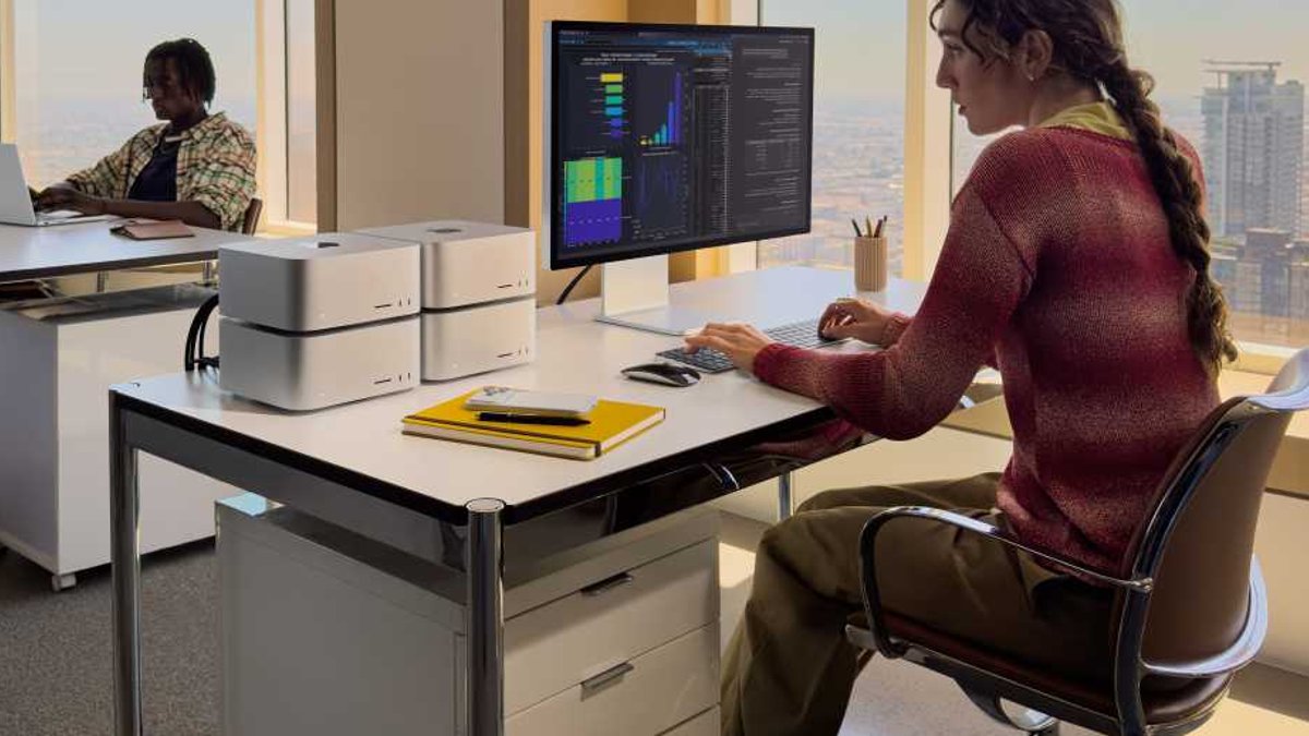 Woman working with a cluster of four Mac Studios.