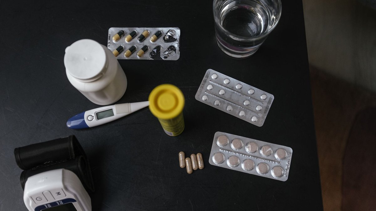 Mobile Chair Scale Links Directly to Digital Records Top view of various medications, tablets, and medical devices on a table with a glass of water.