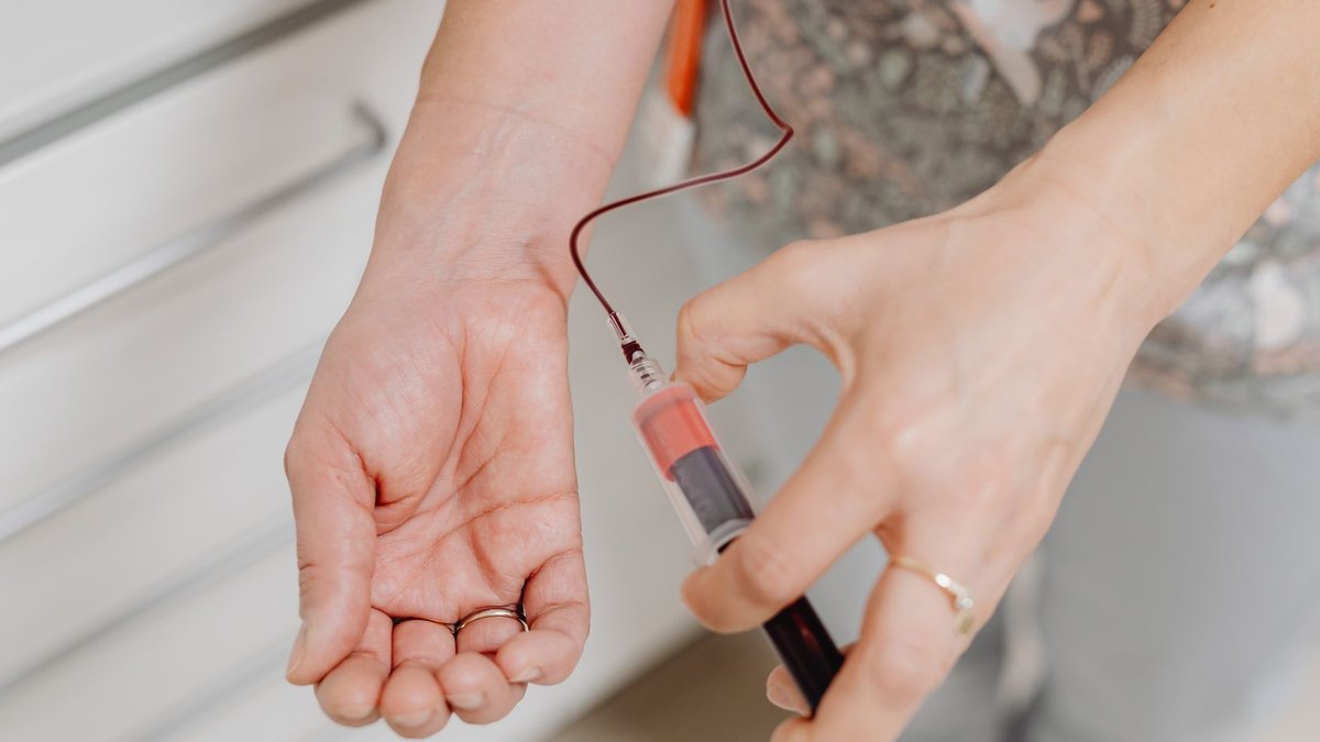 Drug targets iron to curb overproduction in blood disorder A close-up view of a blood draw procedure with syringe and vial, focusing on healthcare treatment.
