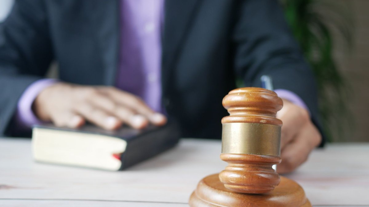 NSW court upholds law firm’s unqualified staff billing rates A wooden gavel and legal book represent justice in a court setting, emphasizing order and legal authority.