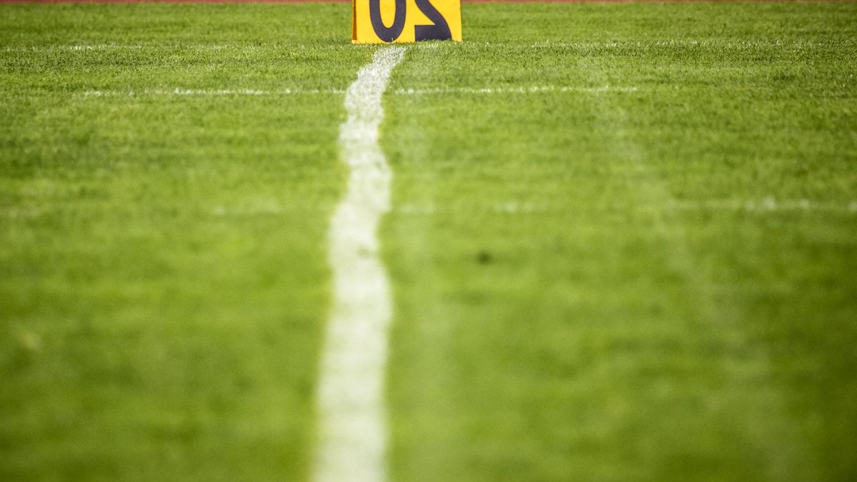Close-up view of a football field with a 20-yard marker, showcasing vibrant green grass.