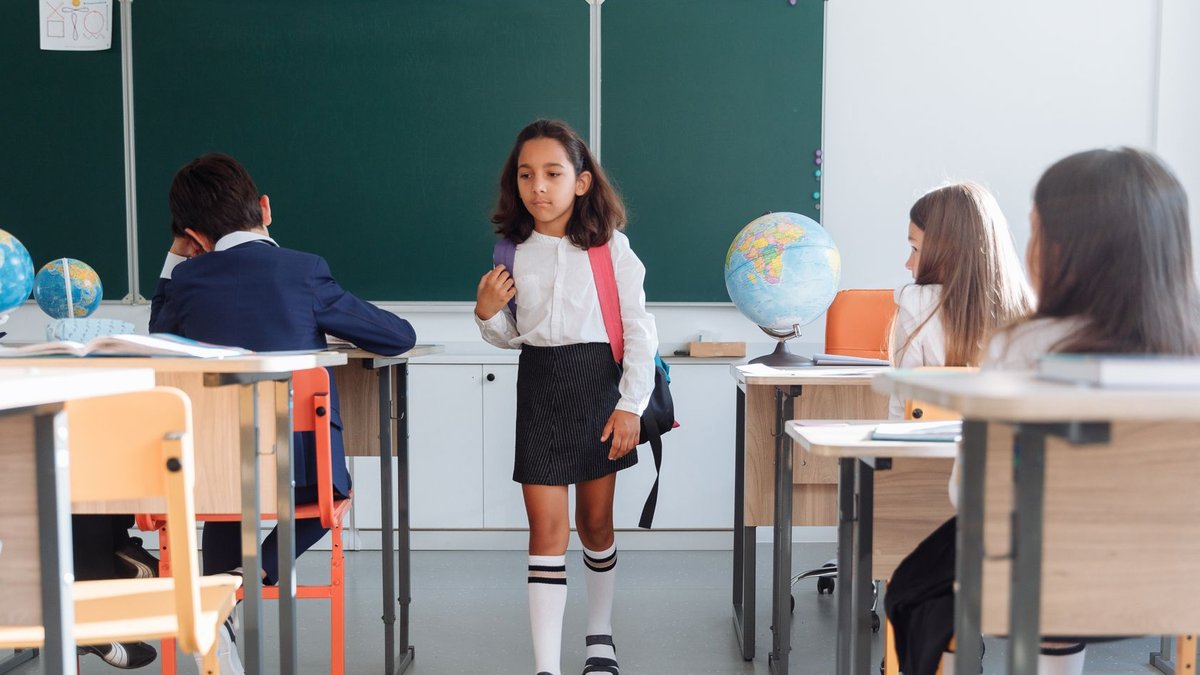 Students in a classroom interacting, showcasing a diverse learning environment.