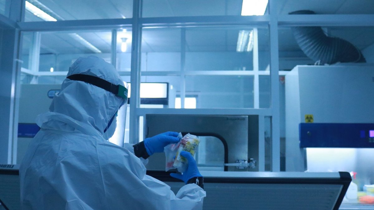 Liverpool launches lab for disease drug discovery Lab technician in full protective suit performs tasks in a controlled laboratory environment.