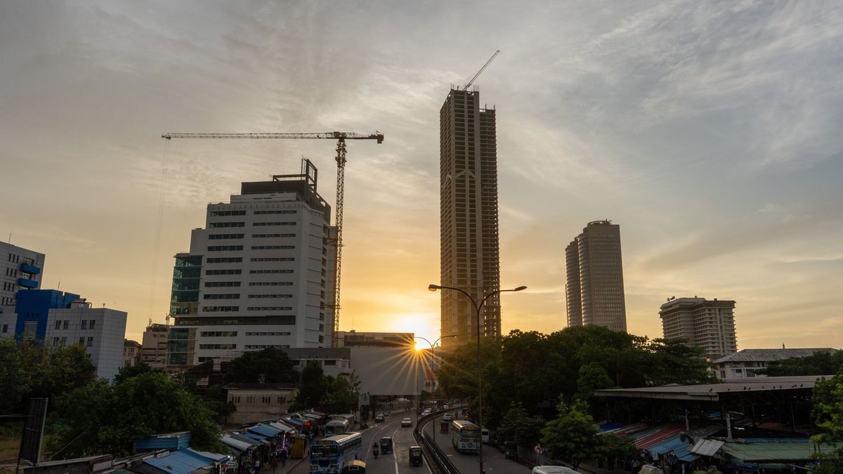 Chennai Developers Explore Colombo's Port City Opportunities A vibrant view of Colombo's skyline at sunset showcasing towering skyscrapers and bustling streets.