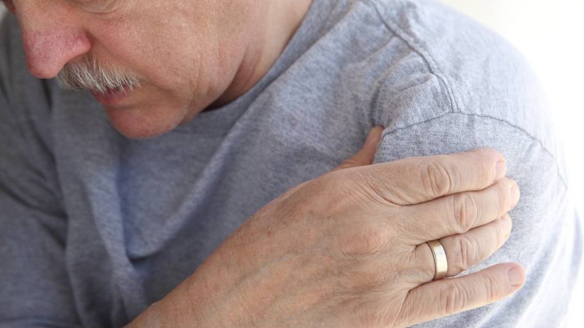 Mayo Clinic Q&A Details Rotator Cuff Tear Treatment Options Closeup of man with head bent forward, holding his hand to his shoulder as if in pain or discomfort.