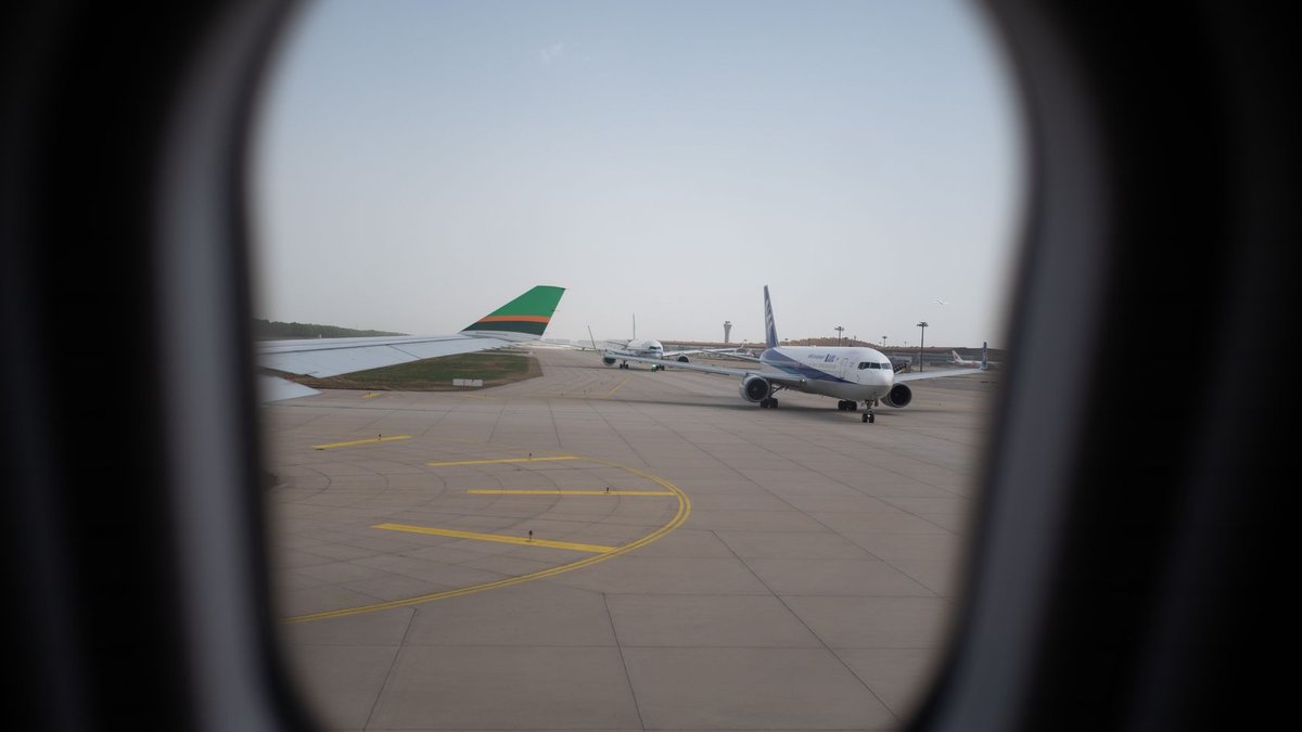 Attack on Riyadh Airport Kills 12 Injures Hundreds Airplane seen through a window, parked on the airport runway, capturing a travel moment.