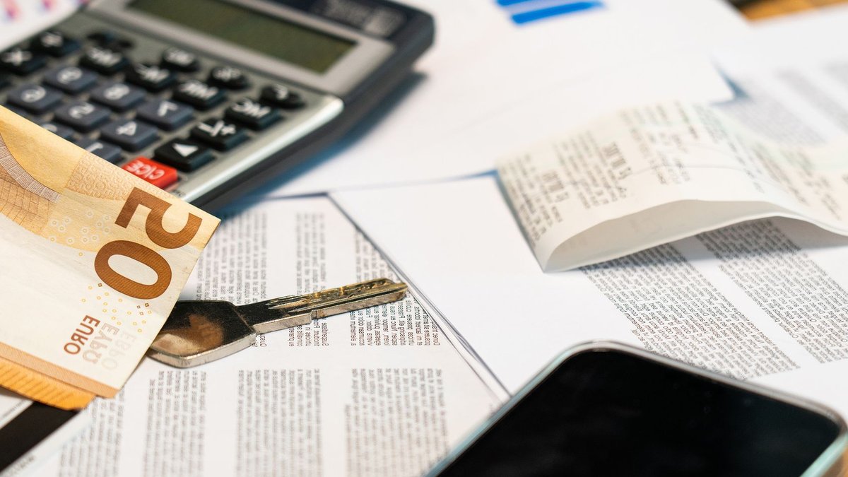 Flat lay of financial documents, euro note, calculator, smartphone, and key for budget management.