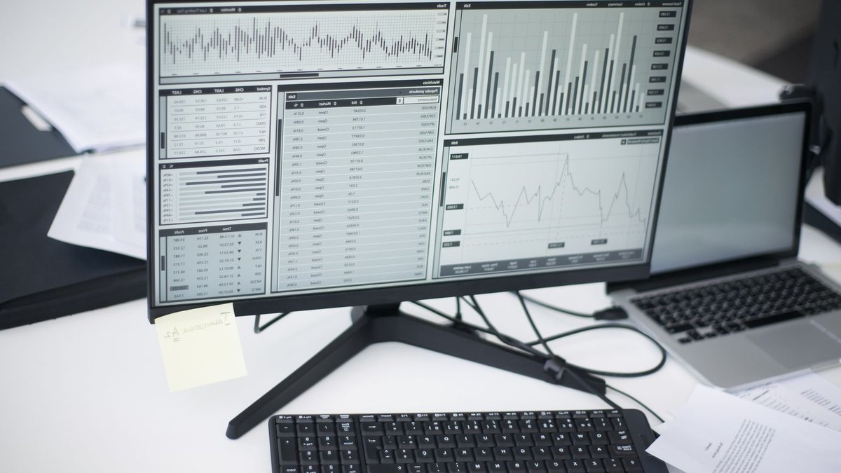 Wealth management firms hire new advisors A professional workspace featuring computers and analytical graphs on a monitor, symbolizing modern business environment.