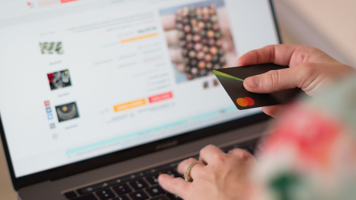Engaging in online shopping using a credit card with a laptop for convenience and ease.