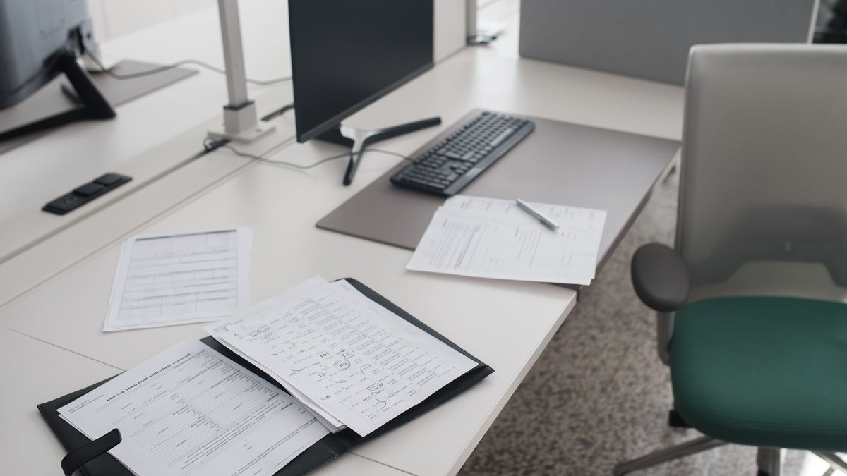 HR professionals seek better understanding at work A clean and organized office desk with documents, a computer, and chair in a modern workspace.