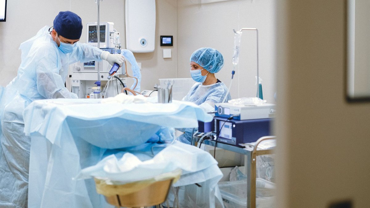 Zimmer extends robotic surgery distribution deal Surgeons and medical staff in a sterile operating room conducting a surgical procedure.