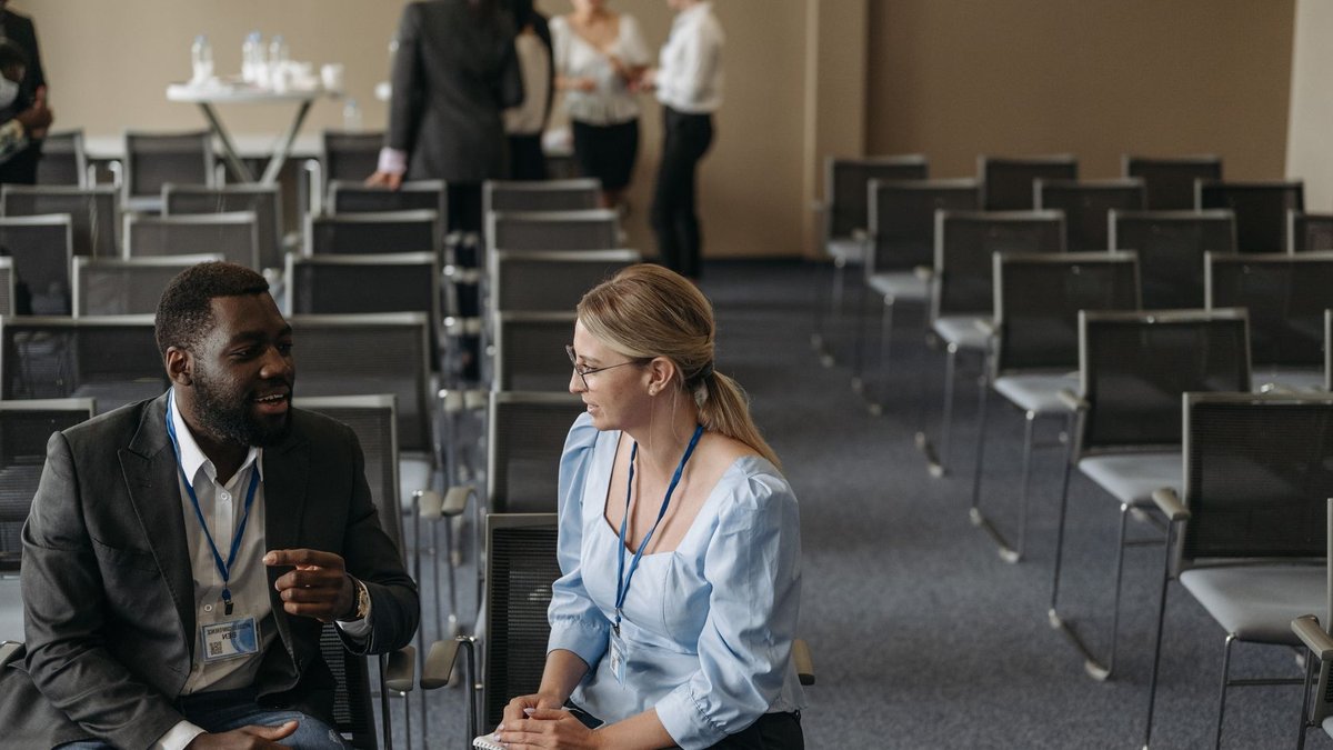 Business professionals having a conversation during a conference break, fostering communication.