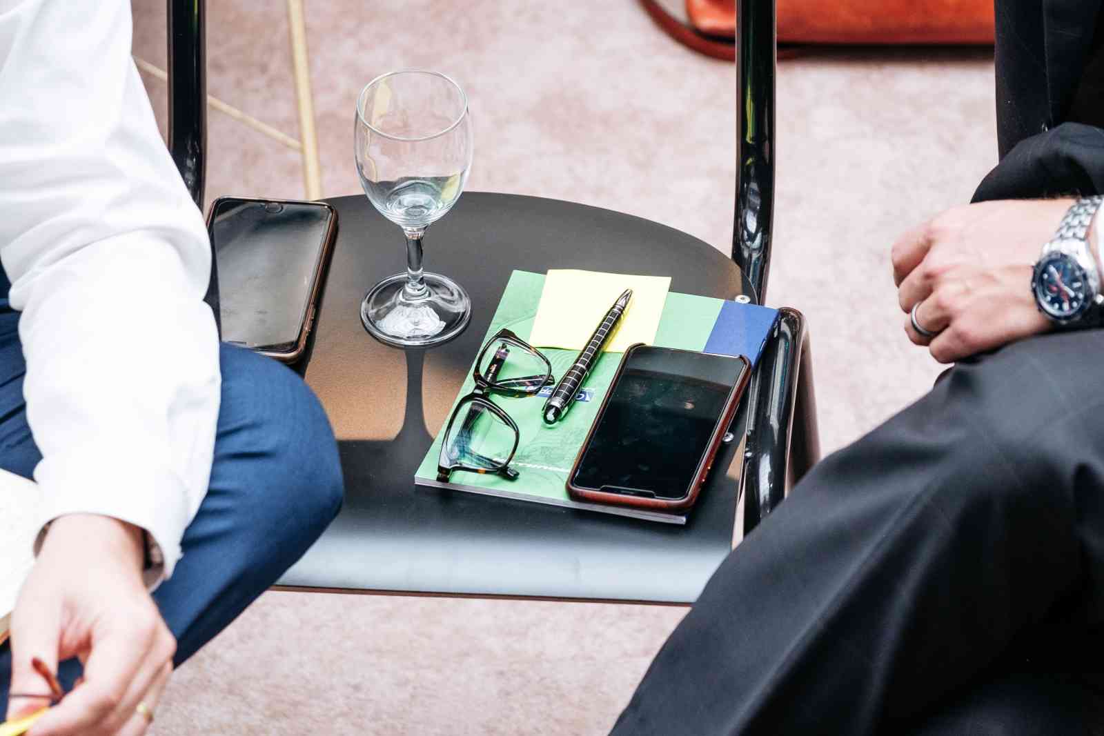 Men talking with belongings on a chair between them