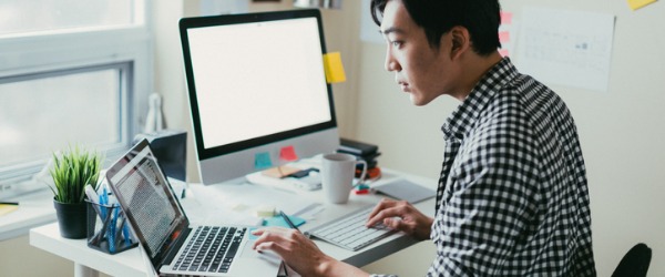 A translator working on his computer, converting the written word from one language to another.