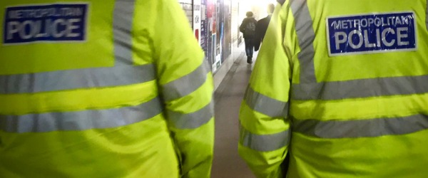 Two transit police officers walking along a subway.