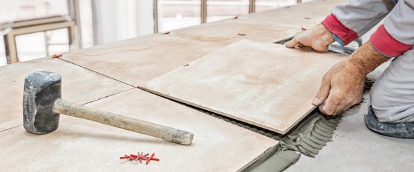 A tile And marble setter laying porcelain tiles.