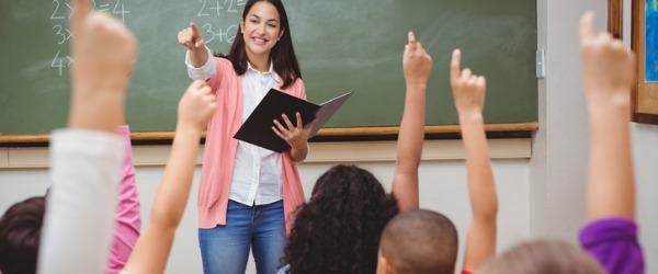 A teacher communicating and motivating her students in the classroom.