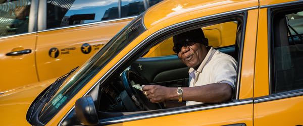 A taxi driver in a taxi cab.
