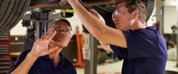 Two recreational vehicle service technicians repairing a recreational vehicle.