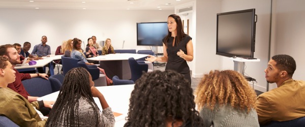 A professor lecturing in front of a group of students.