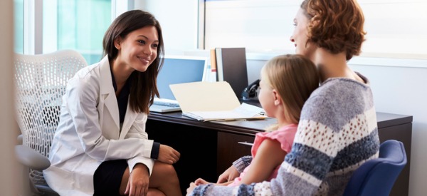 A pediatrician talking to a mother and toddler.