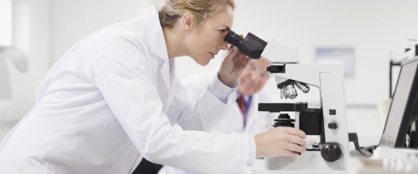 A pathologist looking through a microscope.
