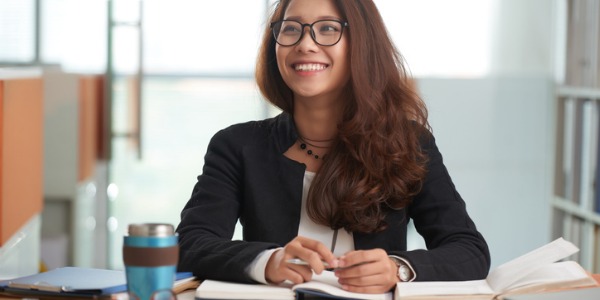 A paralegal sitting at her desk and smiling.