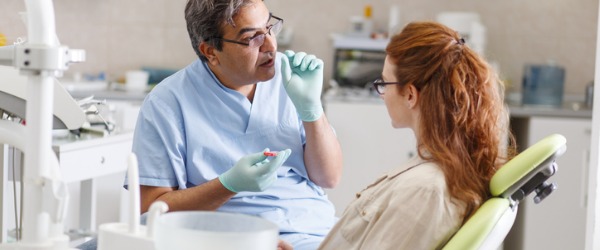 An orthodontist talking to a patient about an effective treatment solution for their misalignment.
