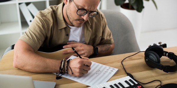 An orchestrator preparing music for an orchestra to perform.