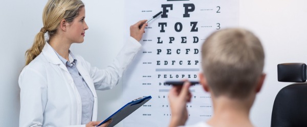 An ophthalmic medical technician helping a patient with their eye examination.
