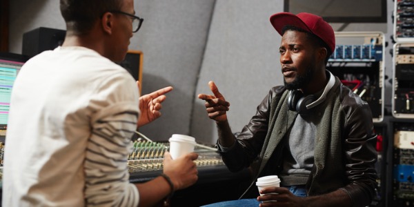 A music publicist sitting in the recording studio with an artist.