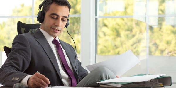 A music executive sitting at his desk with headphones on.