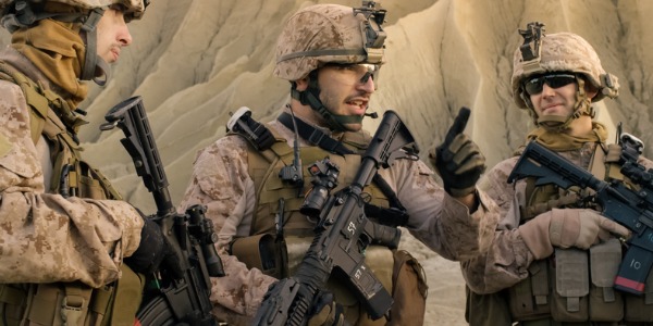 A military tactical operations leader talking to two soldiers in the platoon.