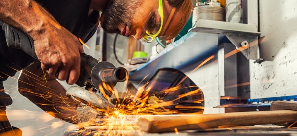 A metal worker grinding metal.