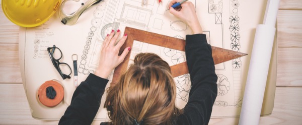 A landscape architect sitting at her desk and designing a layout.