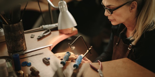 A jeweler is an artisan who uses metals, gems and other materials to create adornments like bracelets, earrings, rings, and necklaces.